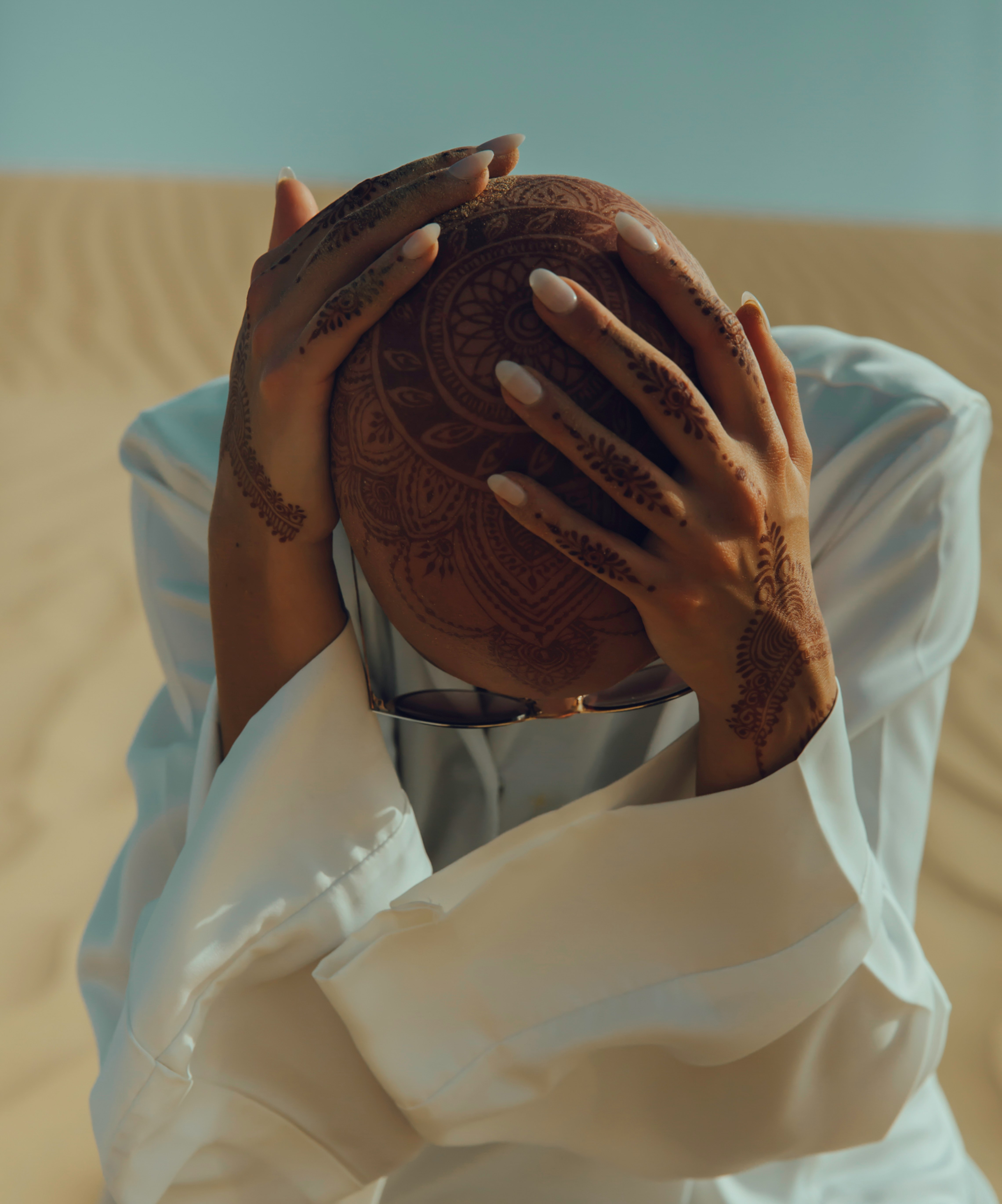 woman sitting on sand in a desert